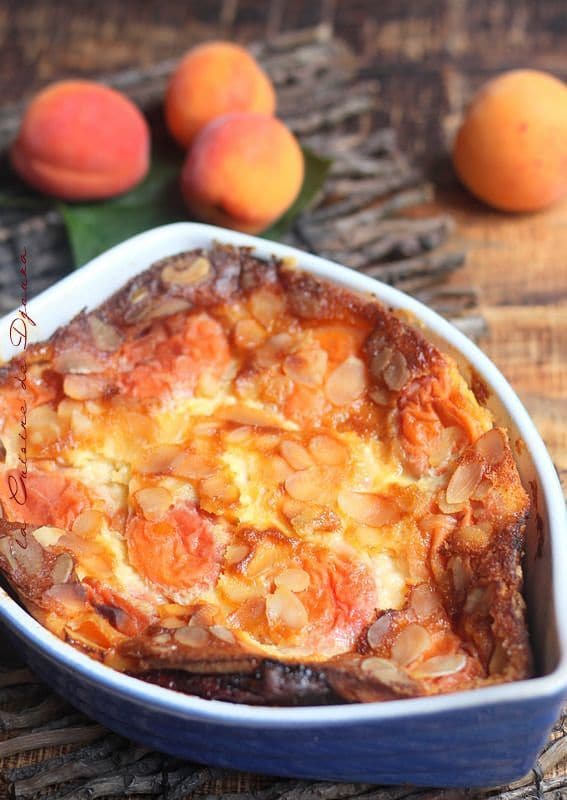 Clafoutis aux abricots frais dans un plat de cuisson avec amandes effilées