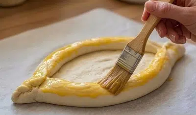 Badigeonnage du pain khachapuri au jaune d'oeuf 